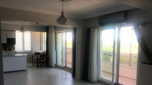Un'ampia cucina con zona pranzo, grandi porte scorrevoli in vetro e una ventola a soffitto.