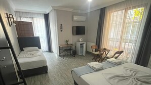 Camera d'albergo con due letti, una scrivania, una sedia, una televisione e una finestra con tende.