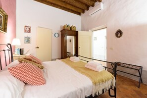 A bedroom with a bed, a bedside table, a mirror, a wardrobe, and a window. - Santo Spirito Dream in Florence by Mmega (Firenze)