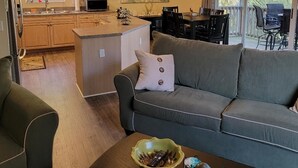 Une cuisine moderne avec des meubles en bois, un îlot central et un coin repas comprenant une table et des chaises.