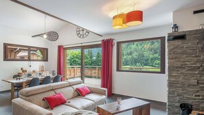 Een moderne woonkamer met een bank, salontafel en een eethoek.