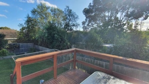 A wooden deck with a metal grill, surrounded by a wooden fence and lush greenery. - City Edge Lower Plenty (Lower Plenty)
