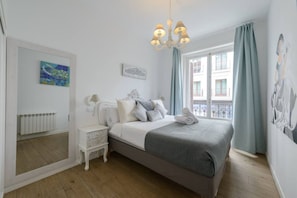 A bedroom with a bed, bedside tables, a radiator, a window with curtains, and artwork on the walls. - 4br 2bth best location SOl, new (Madrid)