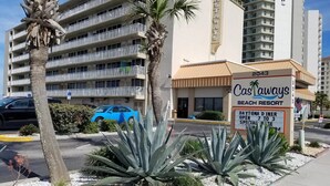 Un immeuble à plusieurs étages, doté de balcons et d’une enseigne indiquant « Castaways Beach Resort ».