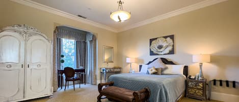 Une chambre à coucher comprenant un lit, une table de chevet, une lampe, une commode et une chaise.