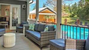 A covered outdoor area with wicker furniture, a pool, and a view of a yard. - Brush Creek Pool House | Luxurious 10BR Home with Pool, Fire Pit, Game Room! (Fairview)