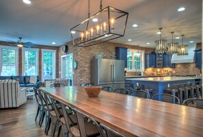Una cocina amplia con una isla de madera, electrodomésticos de acero inoxidable y armarios azules.