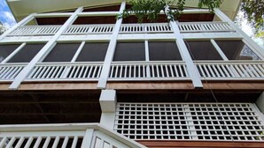 Un immeuble à plusieurs étages, doté de balustrades blanches et d’escaliers en bois.
