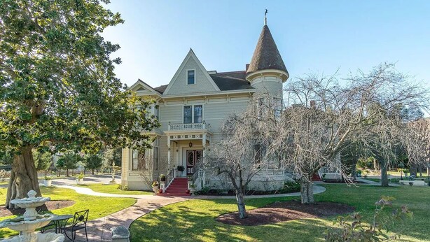 A large, historic house with a prominent turret and a well-maintained front yard. - Penthouse King Suite•Private Floor•Monterey (Salinas)