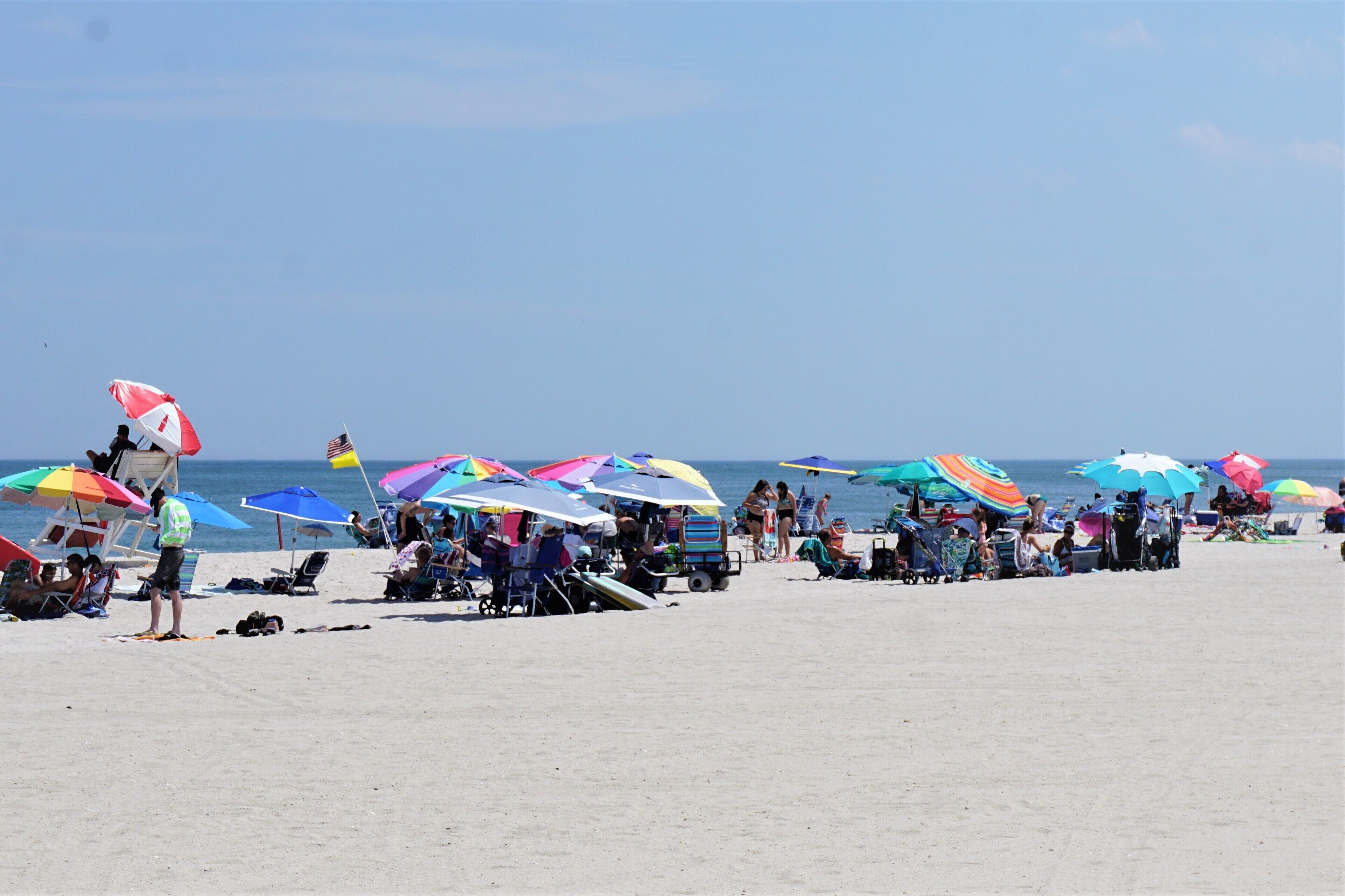 Een strand met kleurrijke parasols en ligbedden.