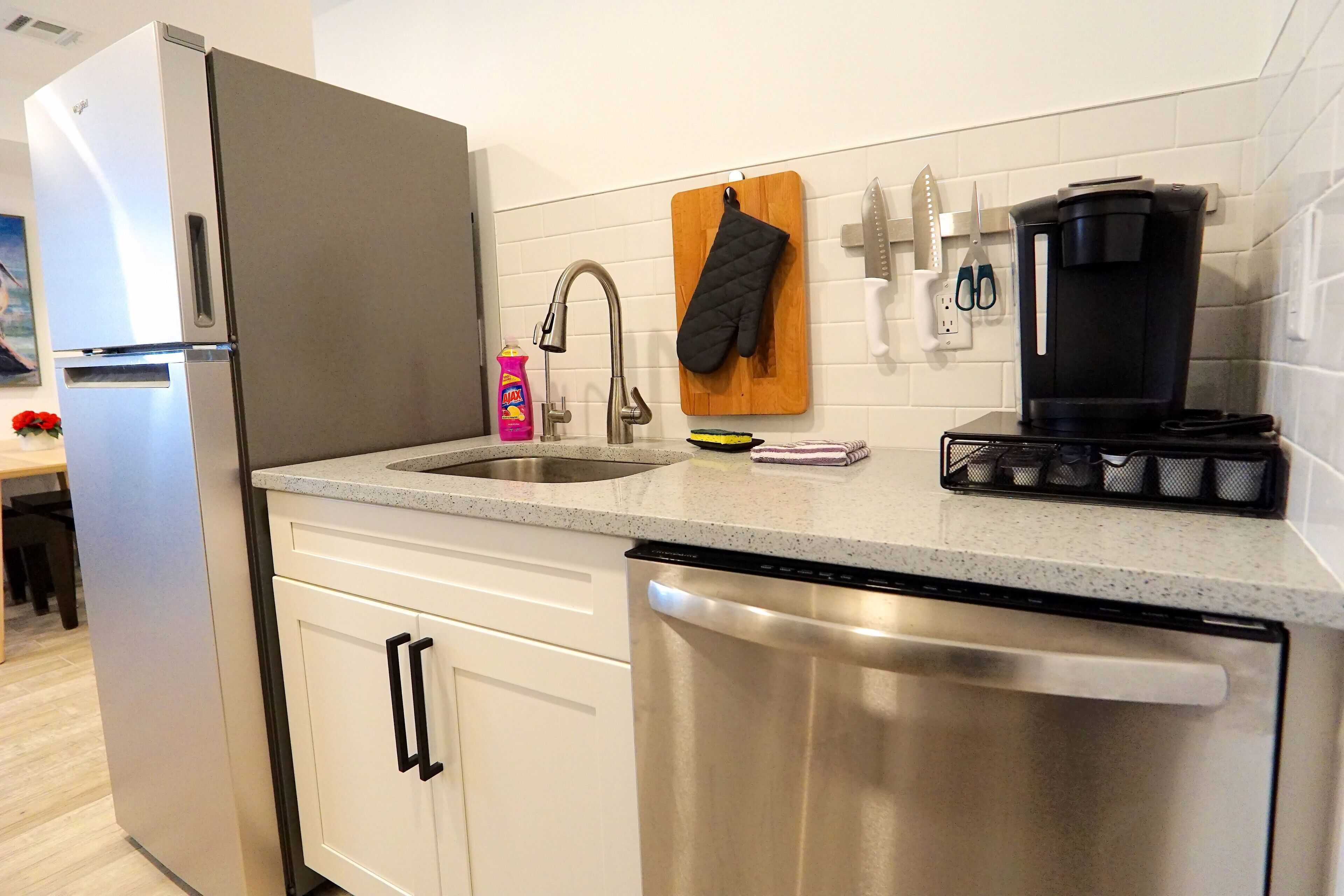 Una cocina moderna con electrodomésticos de acero inoxidable, un lavamanos y una cafetera.