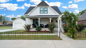 A two-story house with a front porch, a garage, and a covered patio area.