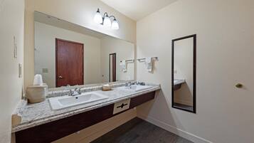 A bathroom with a double sink vanity, a large mirror, and a towel rack.