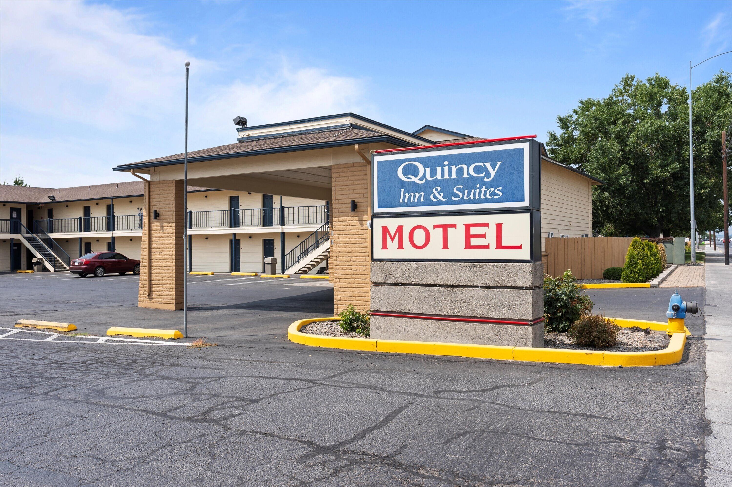 A motel with a sign indicating it is a Quincey Inn & Suites.