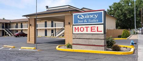 A motel with a sign indicating it is a Quincey Inn & Suites.