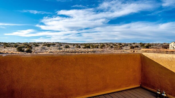 A room with a view of a desert landscape and a house in the distance. - O'Keeffe Paints, XL room with lock for Balloon Fiesta! (Rio Rancho)