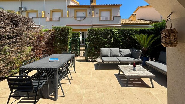 An outdoor patio area with a table and chairs, a sofa, and a hanging lantern. - Casa Florence - L'Estartit, Els Salats (Estartit (L´))
