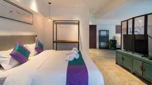 A modern hotel room with a large bed, a television, and a green cabinet. - Manya Hotel (Menghai)