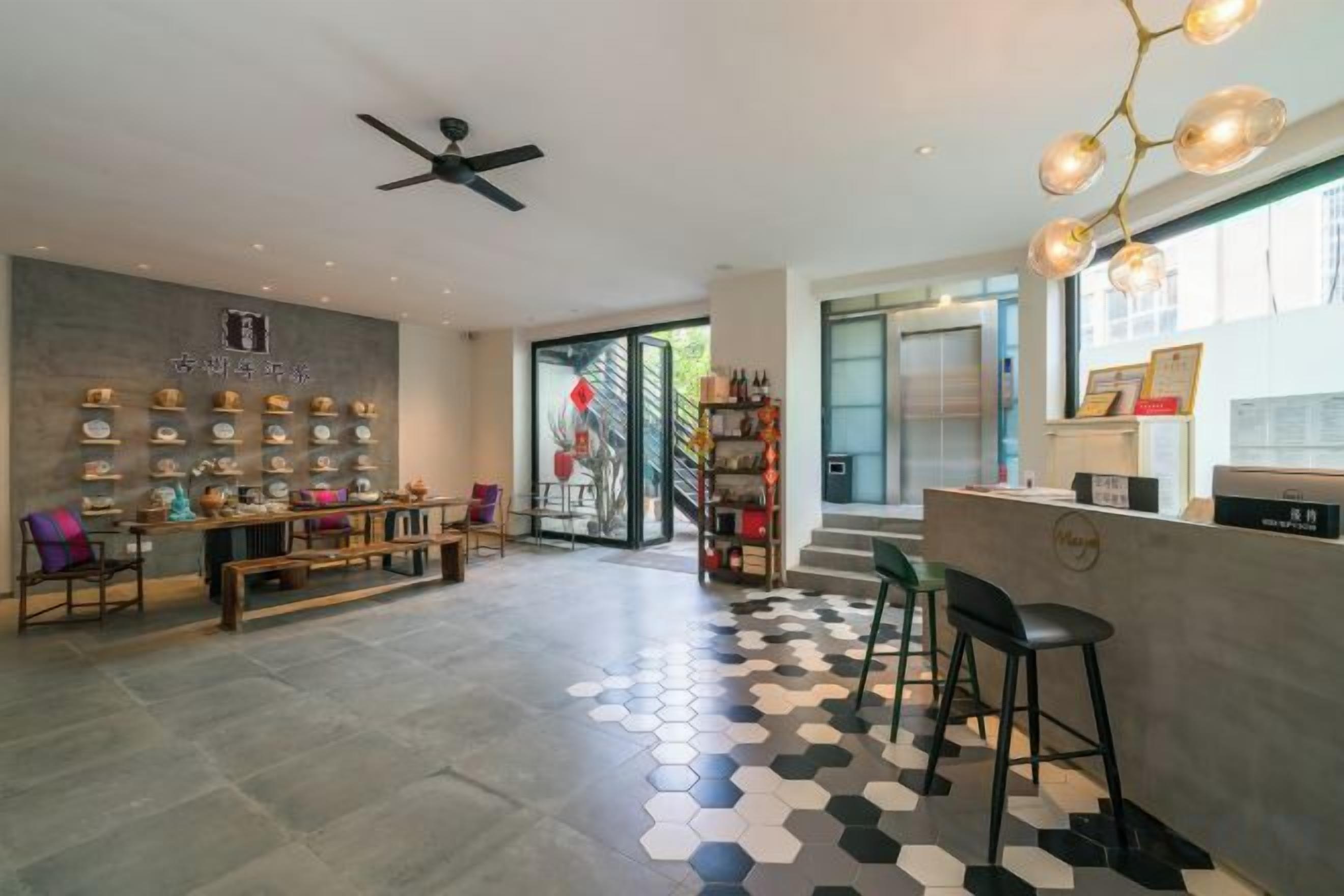 A modern interior with a reception desk, seating area, and a staircase leading to an outdoor area.
