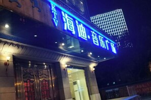 A building with a prominent blue sign with Chinese characters, a traditional entrance with ornate doors, and a modern glass facade. - RONGDE (Hohhot Drum Tower, Jiangjun Yashu Metro Station) (Hohhot)