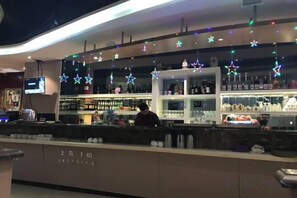 A bar area with shelves stocked with bottles, a counter with a person behind it, and star-shaped decorations hanging from the ceiling. - RONGDE (Hohhot Drum Tower, Jiangjun Yashu Metro Station) (Hohhot)