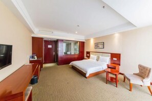 A hotel room with a bed, a desk, a chair, a TV, and a door leading to a bathroom. - RONGDE (Hohhot Drum Tower, Jiangjun Yashu Metro Station) (Hohhot)