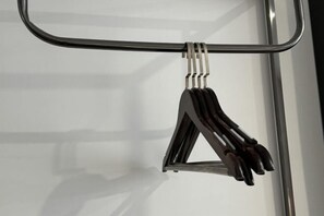 Un objeto metálico de forma triangular suspendido de una barra horizontal, probablemente un elemento de equipo o decoración.