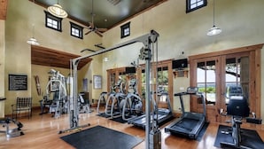 Une salle de sport équipée de tapis de course, de vélos elliptiques et de matériel de musculation.