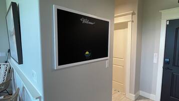 A hallway with a welcome sign, a door, and a chair.