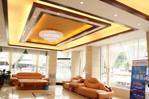 A hotel lobby with a chandelier, sofas, and a large window. - Sunday Business Hotel (Huazhou)