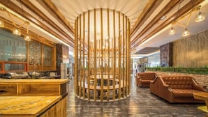 Un interior moderno con una estructura central de bambú, vigas de madera y asientos de cuero.