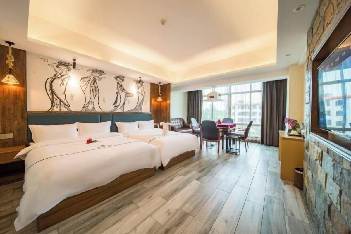 Quarto de hotel com cama grande, área de refeições e vista para a cidade.