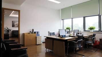 A modern office with a desk, chairs, and a large window.