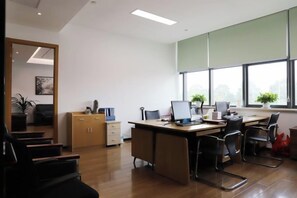 A modern office with a desk, chairs, and a large window.