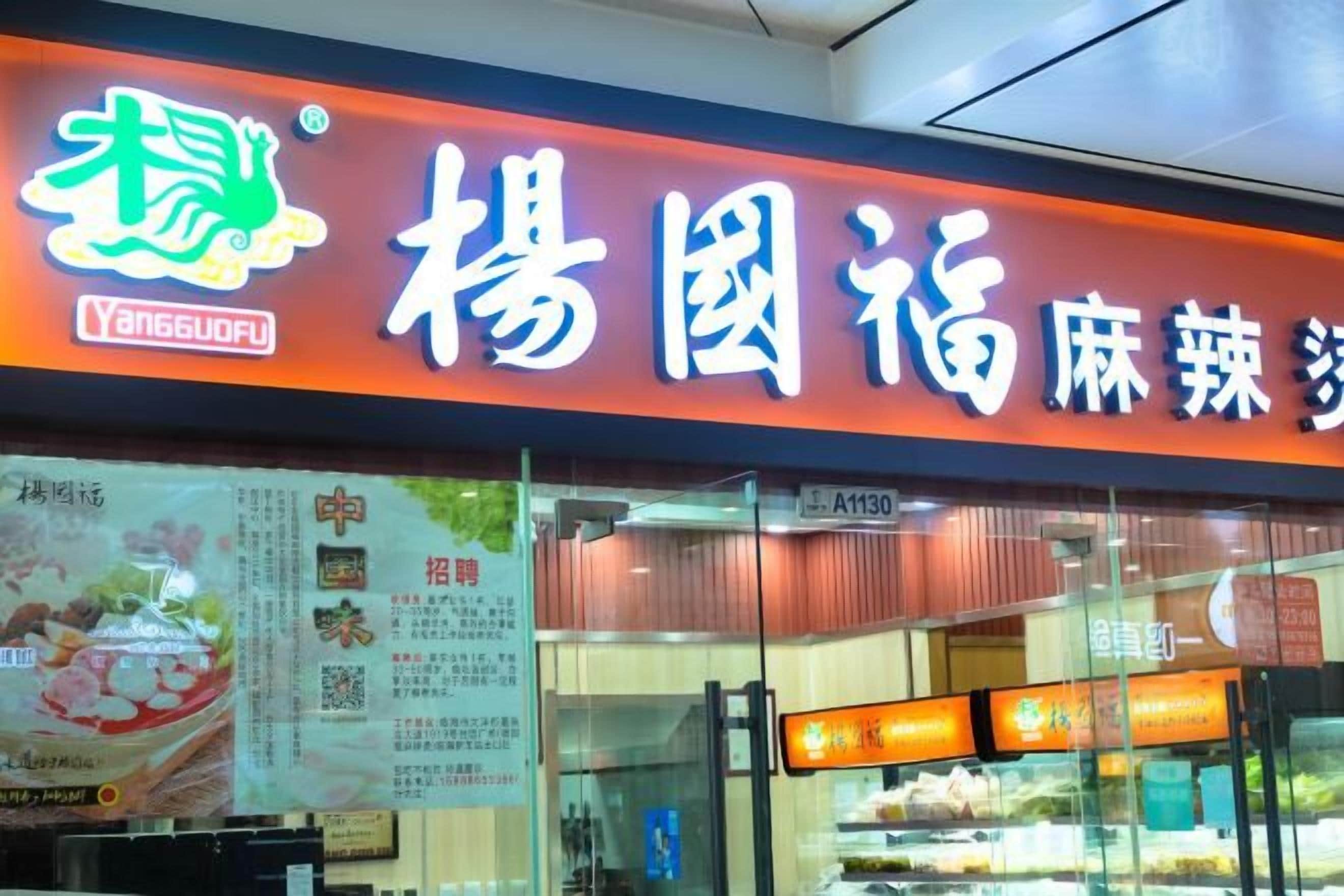 A restaurant with a prominent sign and menu boards visible through the glass.
