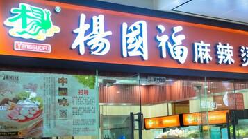 A restaurant with a prominent sign and menu boards visible through the glass.
