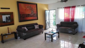 A living room with a sofa, a coffee table, a painting, and a ceiling fan. - close to the sea, Colonial Zone, restaurants and Museums (Santo Domingo)