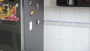 A kitchen with a stainless steel refrigerator, a wooden cabinet, and a tiled backsplash. - close to the sea, Colonial Zone, restaurants and Museums (Santo Domingo)