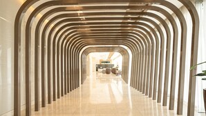 A corridor with a series of arches leading to a reception area.