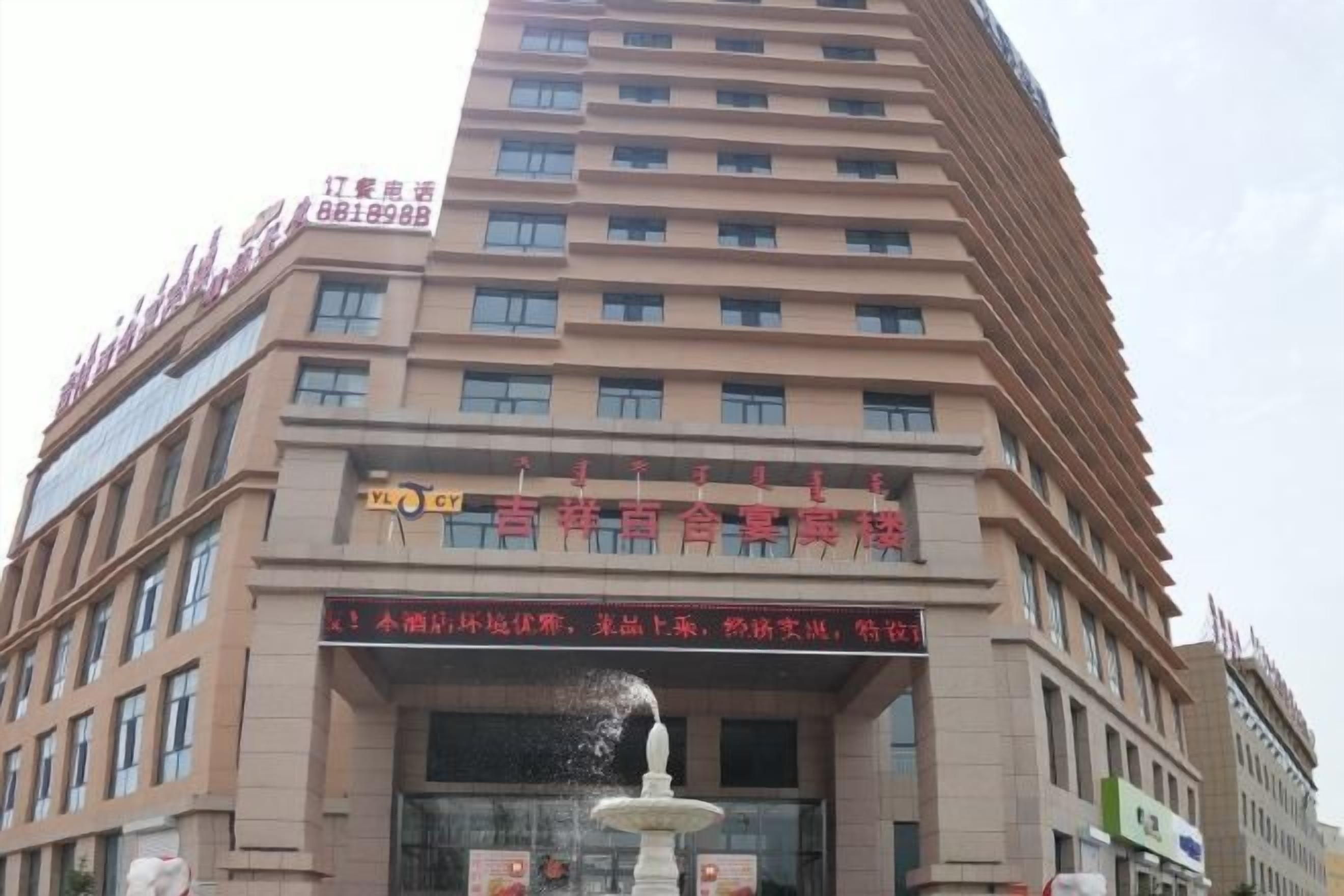 A multi-story hotel with a prominent entrance, a fountain, and several signs indicating amenities and services.
