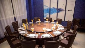 A round dining table with chairs, set for a meal. - Huangsheng Hotel (Wuchuan)