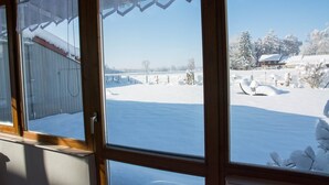 A view through a window with a wooden frame and a clear sky. - Apartment 'Kleiner Spatz' with Terrace, Shared Garden & Wi-Fi (Leutkirch im Allgäu)