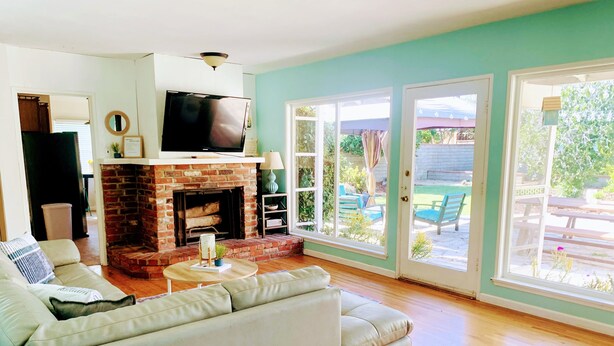 A living room with a fireplace, a television, and a sofa. - Midtown Ventura Family & Pet Friendly Cottage (Ventura)