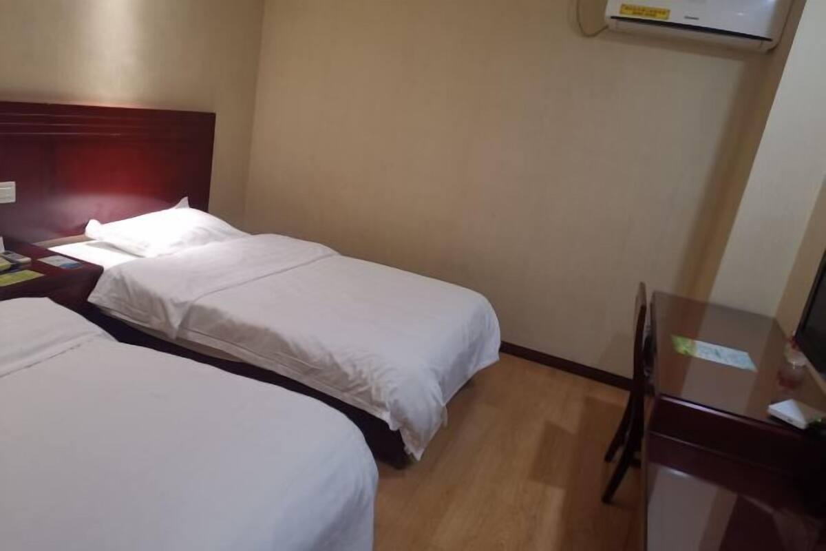 Een hotelkamer met twee bedden, een bureau en een stoel.
