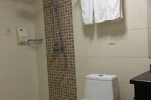 Un bagno con doccia, servizi igienici e asciugamano.