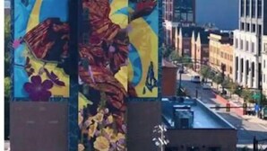 Un edificio con un gran mural que presenta diseños abstractos y motivos florales.