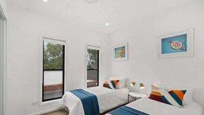 A hotel room with two beds, a small table, and a window. - Stroll to beach, cafes & restaurants (BOOKER BAY)