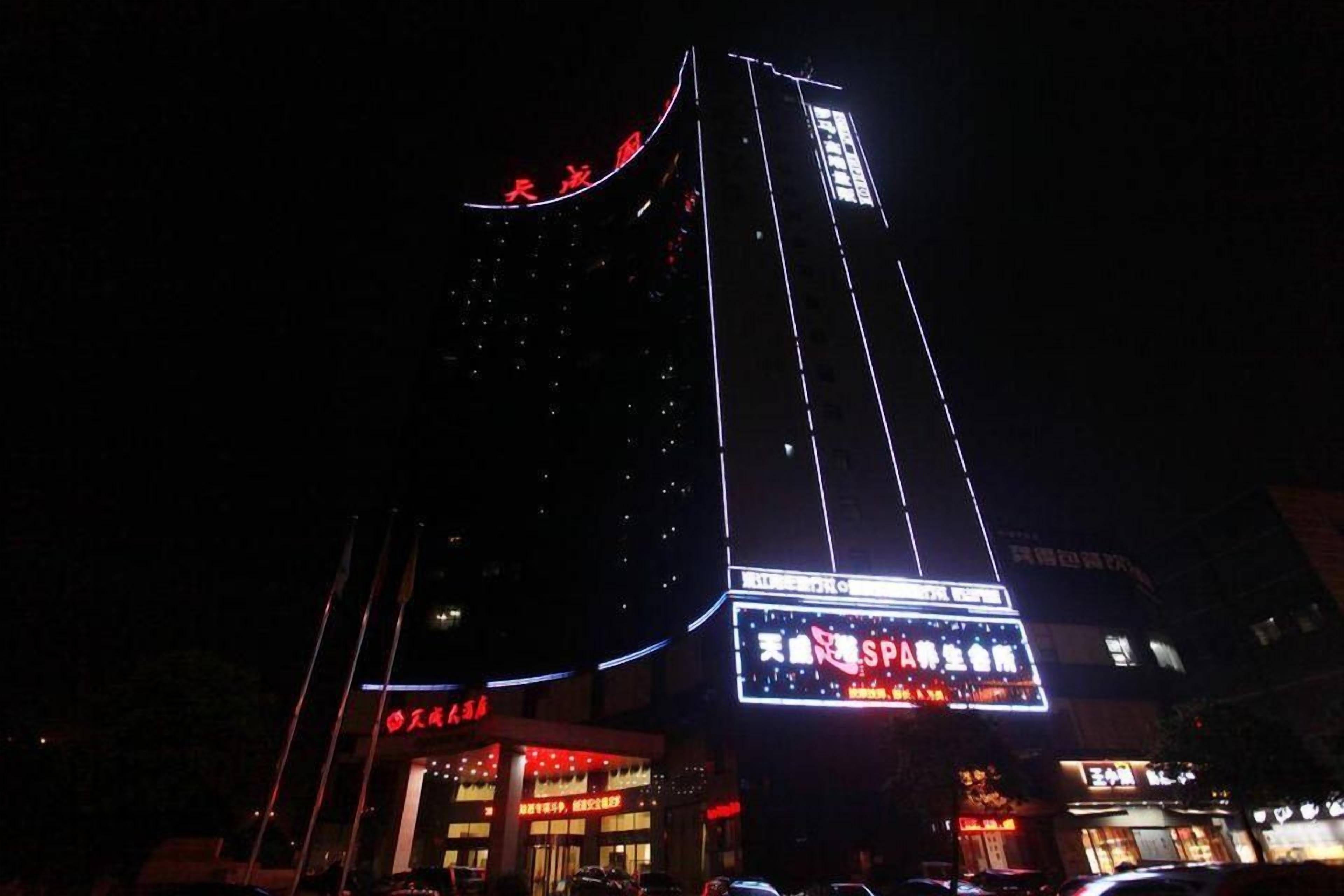 A tall building with illuminated signage at night.