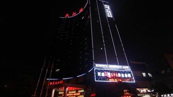 A tall building with illuminated signage at night.