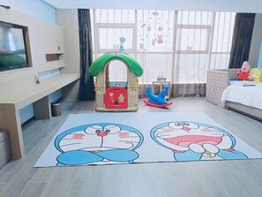A room with a play area, a television, and a window with curtains. - Tiancheng Hotel (Yuanjiang)